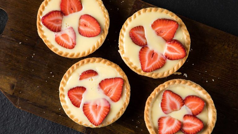 An image of four strawberry and custard tartlets