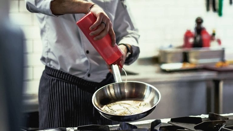 A photo of a chef using oils in the kitchen