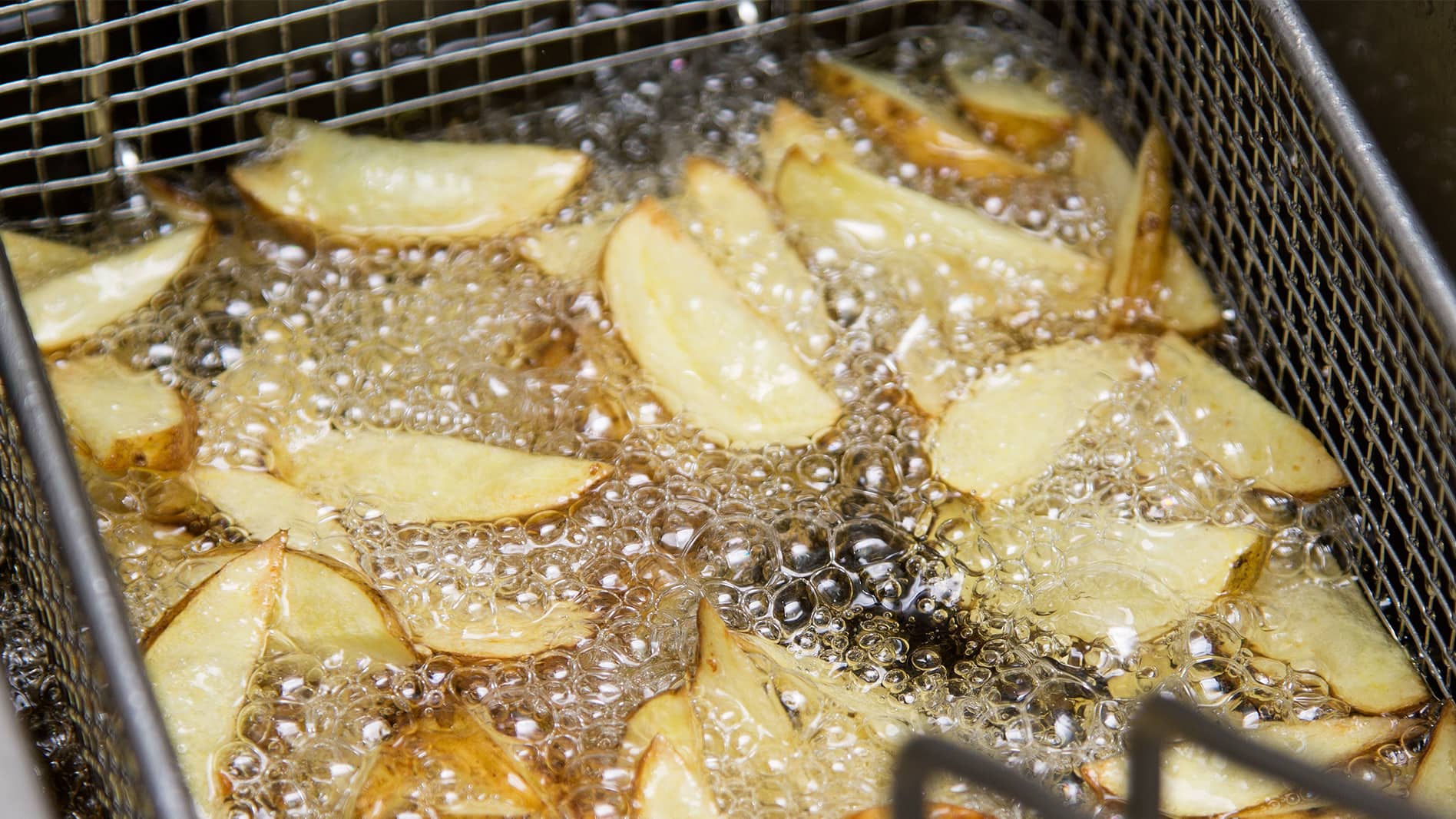 Potato wedges in a deep frier